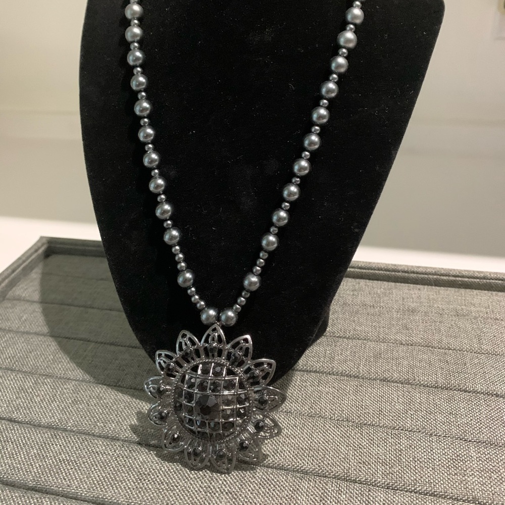 grey pearls with a black medallion necklace
